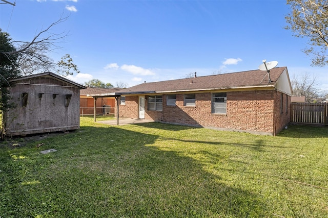 rear view of property with a yard, a fenced backyard, an outdoor structure, a storage shed, and brick siding