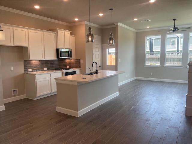 5617 Iris Harvest Dr, Houston, TX 77091 - kitchen with stainless steel microwave, light countertops, white cabinets, dark wood finished floors, and ornamental molding