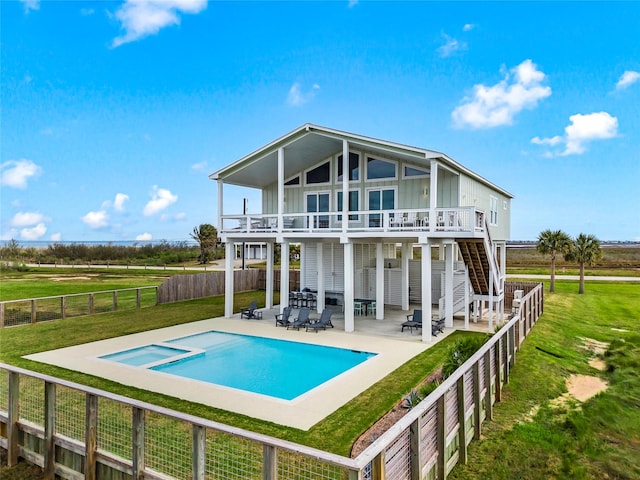 rear view of house with board and batten siding, stairway, a lawn, a fenced backyard, and a patio area