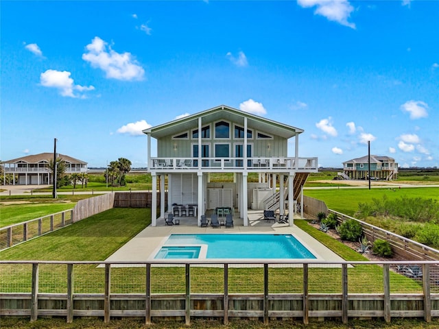 rear view of property featuring a patio, a balcony, a lawn, and a fenced backyard