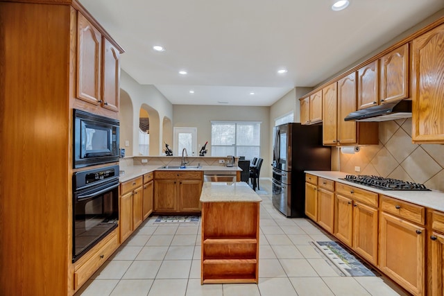 kitchen with black appliances, under cabinet range hood, a sink, a peninsula, and light tile patterned floors