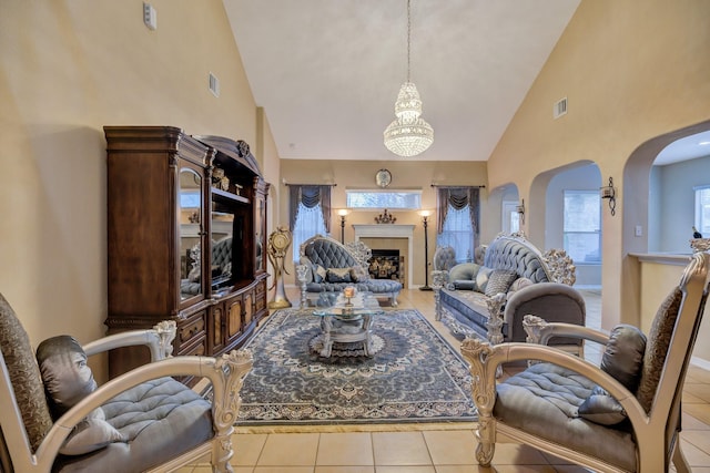 living area featuring light tile patterned floors, visible vents, high vaulted ceiling, and a fireplace