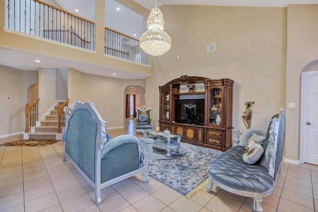 living area with visible vents, tile patterned floors, a chandelier, stairway, and arched walkways