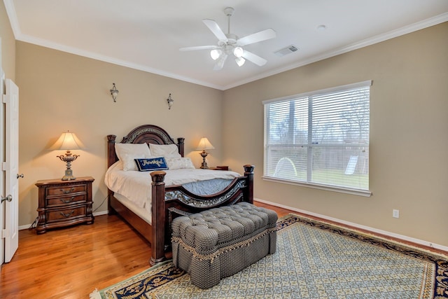 bedroom featuring visible vents, ornamental molding, a ceiling fan, light wood finished floors, and baseboards