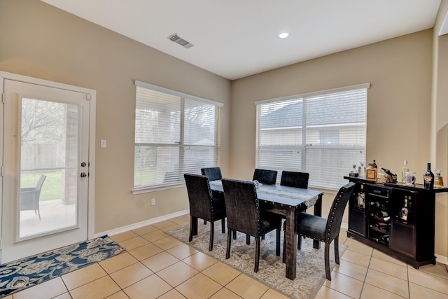 dining room featuring light tile patterned floors, baseboards, and visible vents