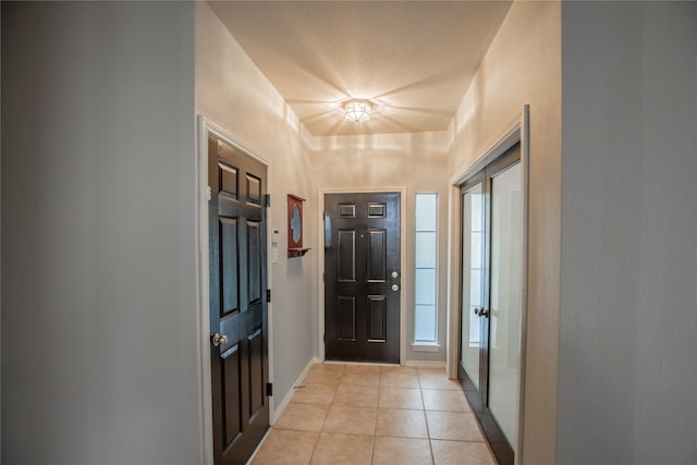 foyer with light tile patterned floors and baseboards