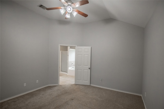 spare room with a ceiling fan, visible vents, baseboards, lofted ceiling, and light colored carpet