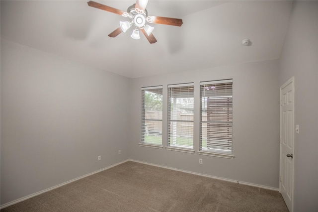 carpeted empty room featuring a ceiling fan, baseboards, and vaulted ceiling