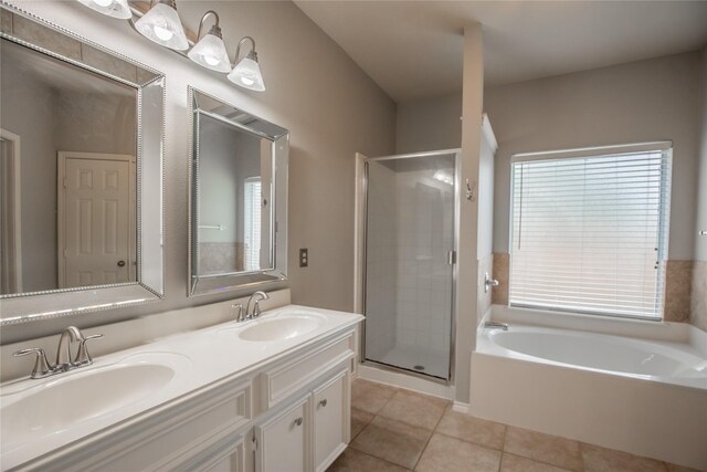 full bathroom featuring tile patterned flooring, a stall shower, a garden tub, and a sink