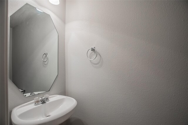 bathroom with a textured wall and a sink