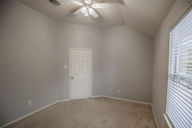 empty room featuring visible vents, light carpet, a ceiling fan, baseboards, and vaulted ceiling