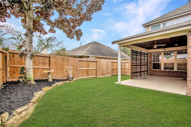 view of yard with a ceiling fan, a patio area, and a fenced backyard