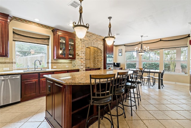 kitchen with visible vents, a sink, decorative backsplash, appliances with stainless steel finishes, and a center island