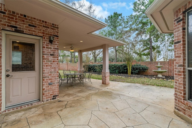 view of patio with outdoor dining area, a ceiling fan, and fence