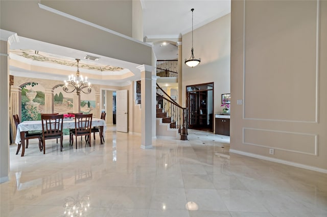 foyer with visible vents, ornate columns, stairs, crown molding, and a notable chandelier