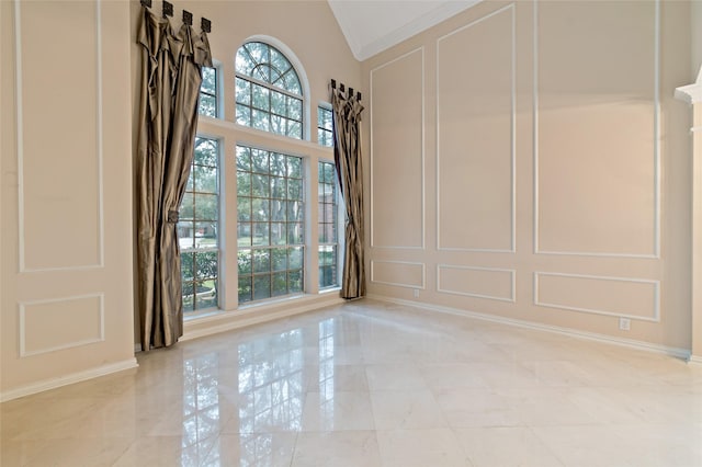 empty room with a decorative wall and high vaulted ceiling