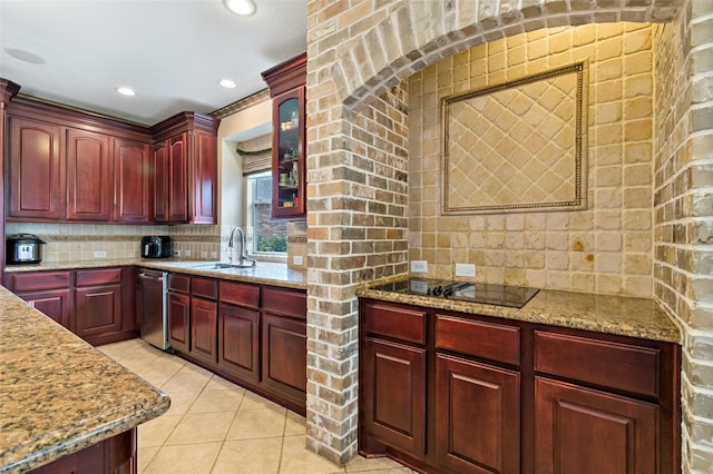 kitchen with tasteful backsplash, light stone countertops, light tile patterned floors, black electric cooktop, and reddish brown cabinets