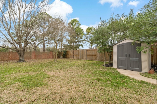 view of yard featuring a storage unit, a fenced backyard, and an outdoor structure