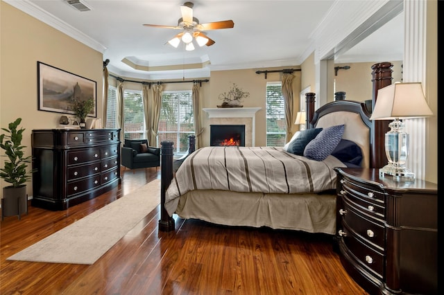 bedroom with visible vents, multiple windows, wood finished floors, and crown molding