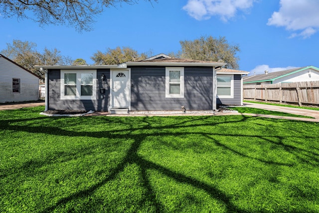 view of front facade featuring entry steps, a front yard, and fence