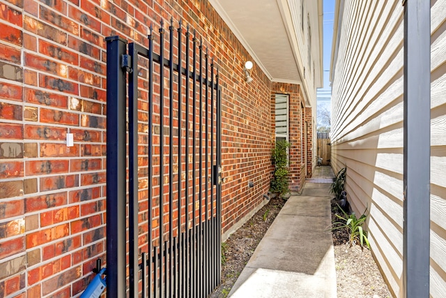 view of side of home featuring brick siding and fence