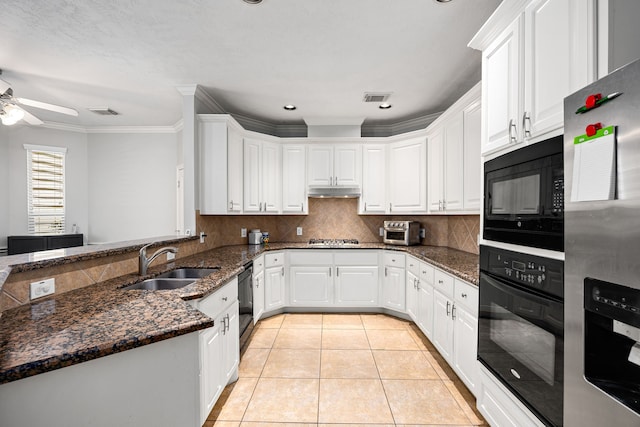 kitchen with visible vents, black appliances, a sink, light tile patterned floors, and decorative backsplash