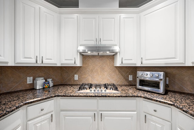 kitchen with white cabinetry, stainless steel gas stovetop, backsplash, and under cabinet range hood