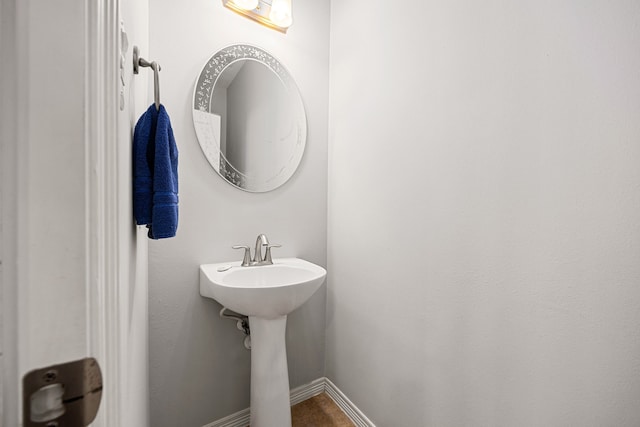 bathroom featuring baseboards and a sink