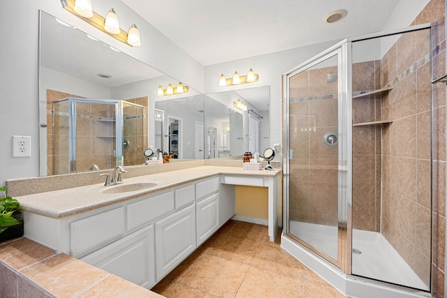 bathroom featuring tile patterned floors, a stall shower, and vanity