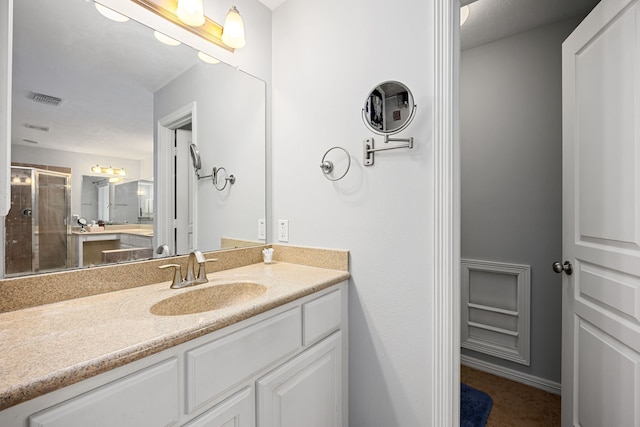 full bathroom with visible vents, a shower stall, and vanity