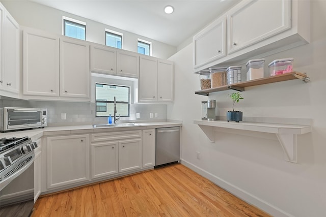 kitchen with tasteful backsplash, a toaster, light countertops, gas range, and dishwasher