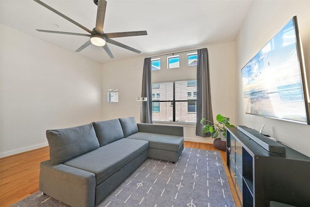 living area featuring ceiling fan, baseboards, and wood finished floors