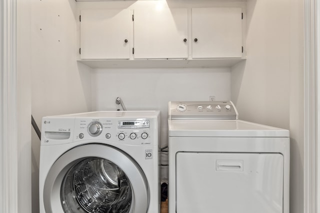 washroom with cabinet space and washing machine and clothes dryer