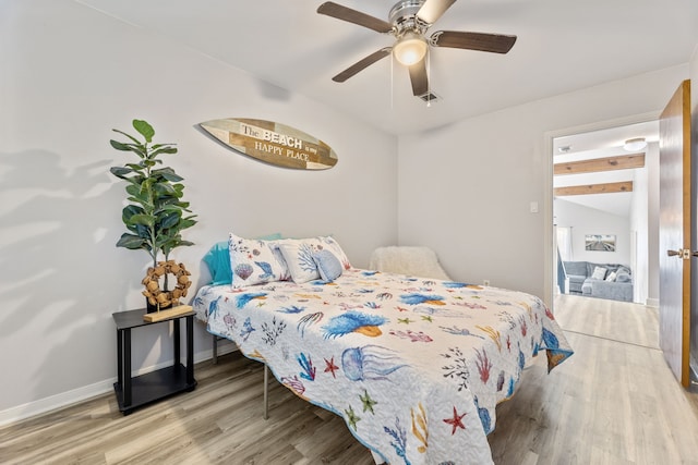 bedroom featuring visible vents, baseboards, wood finished floors, and a ceiling fan