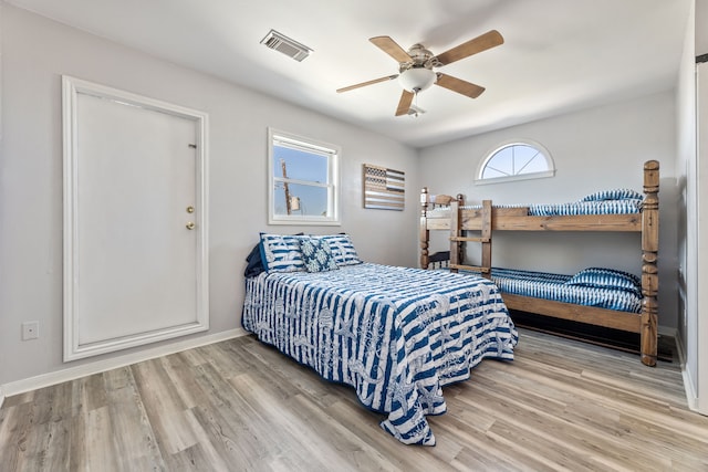 bedroom with visible vents, ceiling fan, baseboards, and wood finished floors