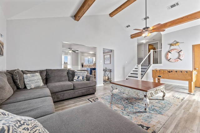 living area with stairway, visible vents, and wood finished floors