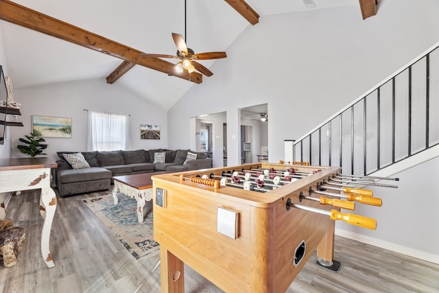 game room featuring ceiling fan, beamed ceiling, baseboards, and wood finished floors