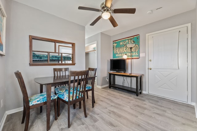 dining area featuring baseboards, a ceiling fan, and light wood finished floors