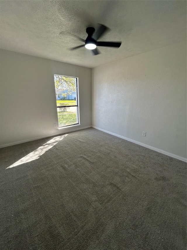 empty room featuring a textured ceiling, a ceiling fan, baseboards, and carpet floors