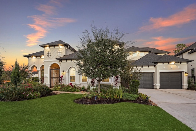 view of front of house with a lawn, concrete driveway, a garage, and stucco siding