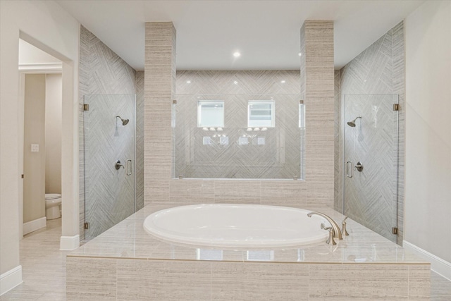 bathroom featuring baseboards, a stall shower, toilet, and a garden tub