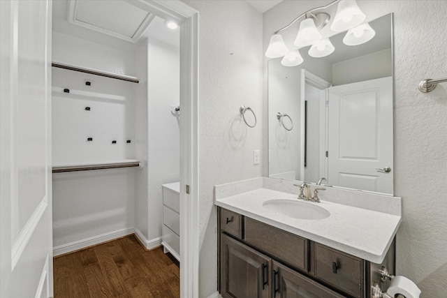 bathroom featuring vanity, baseboards, and wood finished floors