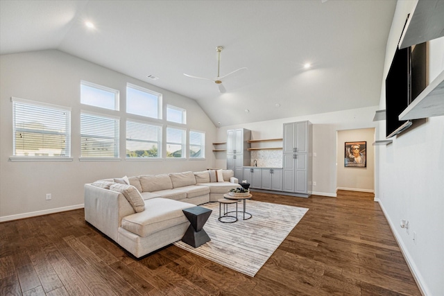 living room featuring baseboards, wood finished floors, a ceiling fan, and vaulted ceiling