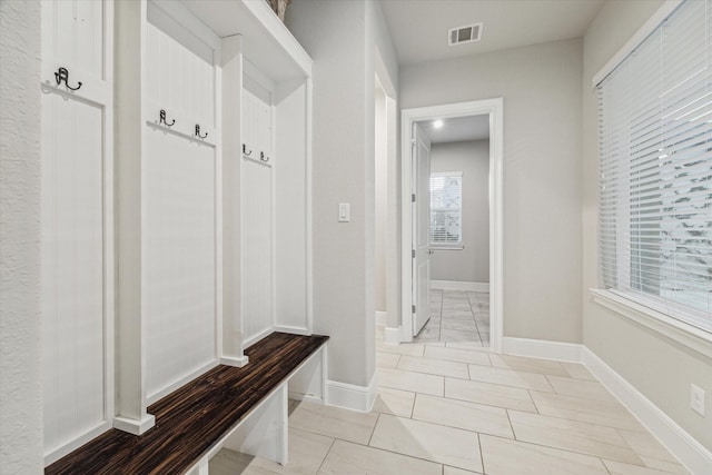 mudroom with light tile patterned floors, visible vents, and baseboards