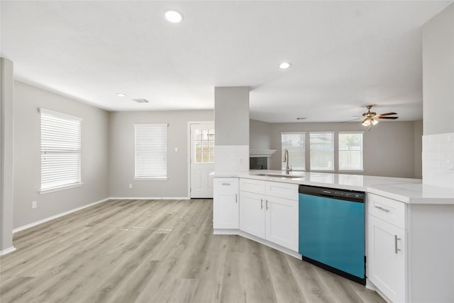 kitchen with a sink, white cabinets, open floor plan, dishwasher, and light wood-type flooring