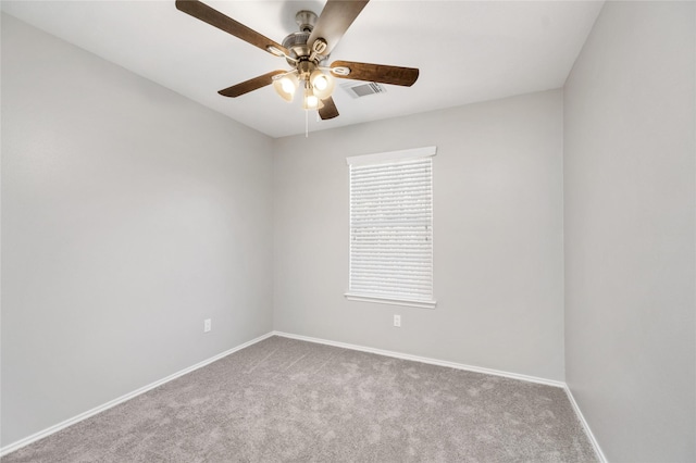 empty room with visible vents, carpet floors, baseboards, and a ceiling fan