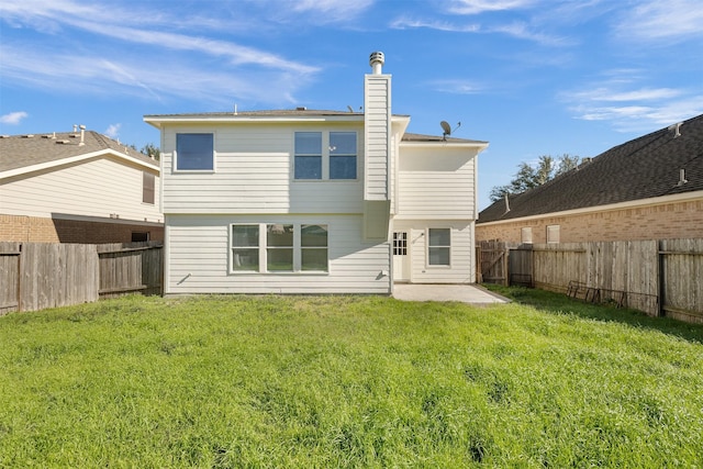 rear view of house featuring a fenced backyard, a patio, a chimney, and a yard