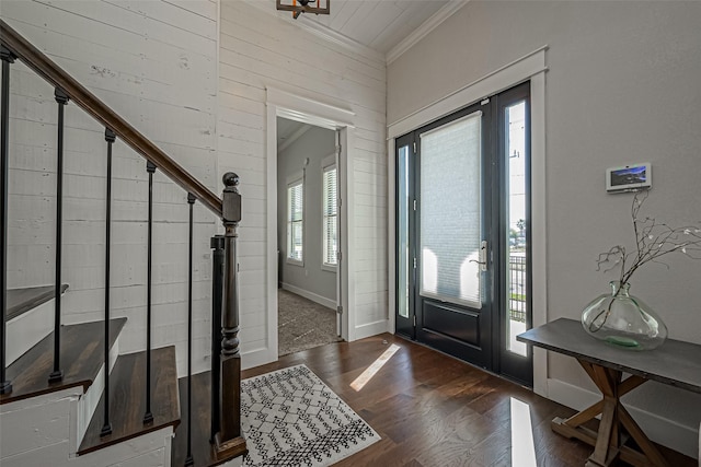 entrance foyer featuring wood finished floors, stairs, and ornamental molding