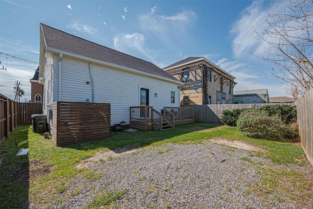 rear view of property with a lawn, roof with shingles, and a fenced backyard