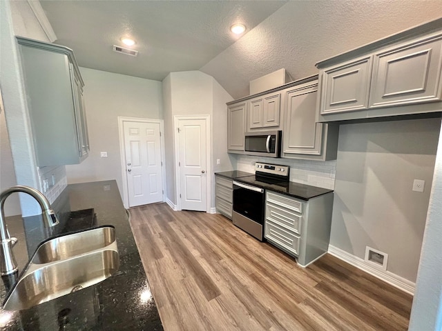 kitchen with light wood-style flooring, visible vents, appliances with stainless steel finishes, and a sink